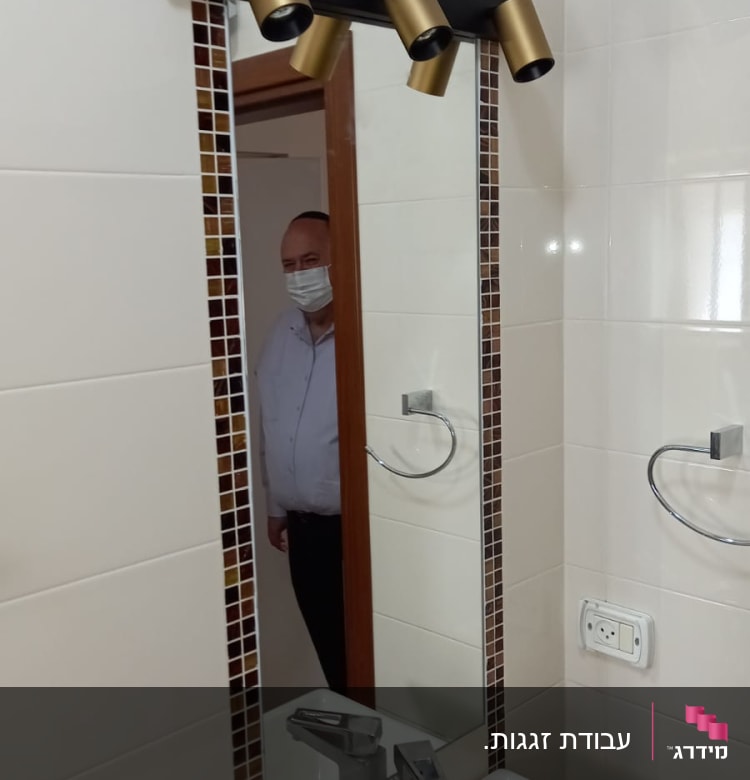 מראה עם מסגרת פסיפס בחדר אמבטיה